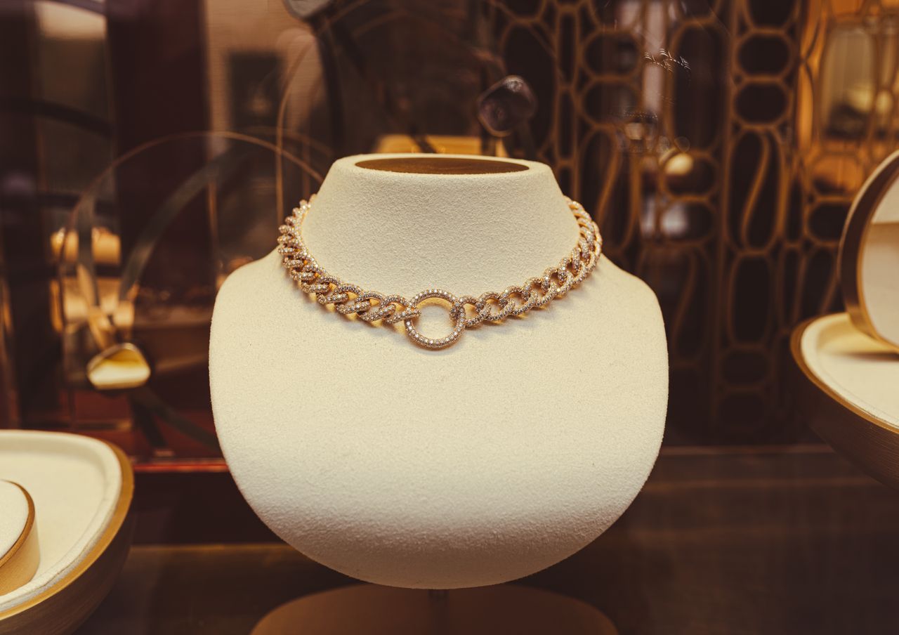 Elegant gold necklace showcased in a luxurious store setting, exuding elegance and style.